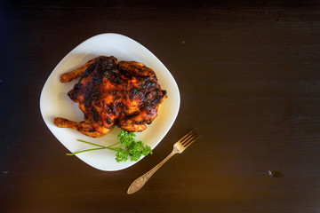 baked chicken on a dark wooden background.
