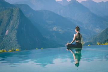 Fototapeta na wymiar Beautiful Attractive Asian woman practice yoga Lotus pose on the pool above the Mountain peak in the morning in front of beautiful nature views in SAPA vietnam,Feel so comfortable and relax in holiday