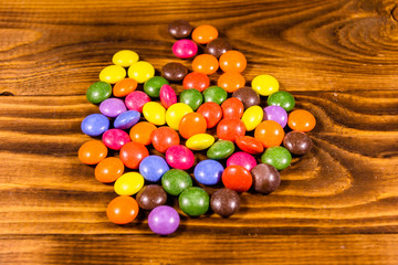 Fototapeta na wymiar Pile of the multicolored candies on a wooden table