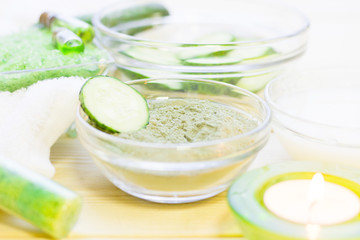 Cucumber home spa and hair care concept. Sliced cucumber, bottles of oil, sea salt, bathroom towel. White board background