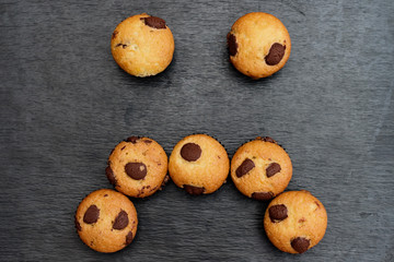 Chocolate chip muffins with sad face shape.