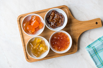 Various Ceramic bowl of Fruit jams Fig, Quince, Bergamot Citrus, Watermelon in wooden tray / Marmalade