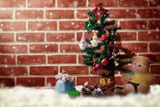 Accessories Christmas and Happy New Year Both teddy bears. Christmas tree Adorned with snow dolls gift boxes Pine cones placed on the floor In room with red wall. Decoration in festivals of happiness.