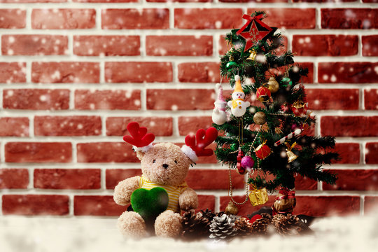 Accessories Christmas and Happy New Year Both teddy bears. Christmas tree Adorned with snow dolls gift boxes Pine cones placed on the floor In room with red wall. Decoration in festivals of happiness.