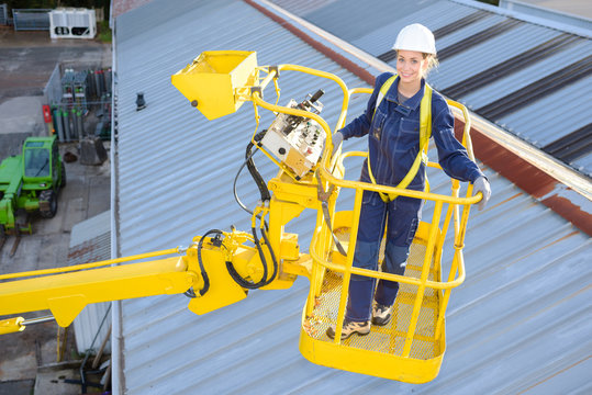 Portrait of woman in cherry picker bucket