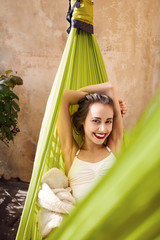 happy young woman relaxed lies in a hammock on the balcony House