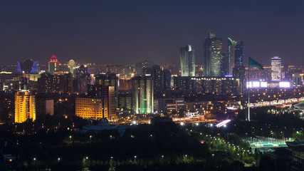 Obraz premium Elevated night view over the city center and central business district with bayterek Timelapse, Kazakhstan, Astana