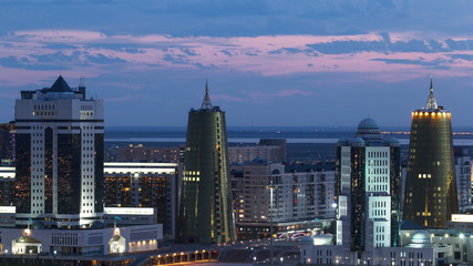 Elevated night view over the city center and central business district with yellow towers Timelapse, Kazakhstan, Astana