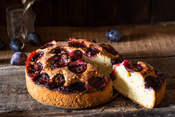 Homemade plum pie on the old wooden background. Still life of food. plum tart. Autumn harvest. Old fashion cuisine. Portion of pie. Plum bakery. Rustic open pie. Winter pie. New York pie.