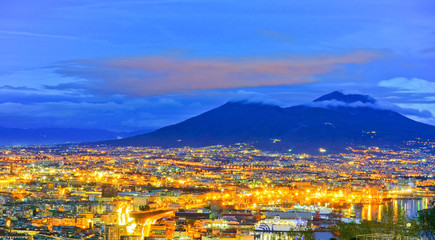Naklejka premium View of the city center of Naples and Mount Vesuvius along the Gulf of Naples at night in Naples, Italy.