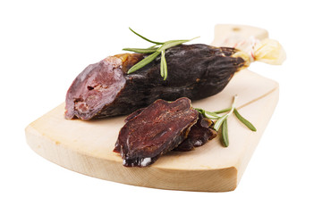 Smoked sausage on cutting board with rosemary isolated on white background