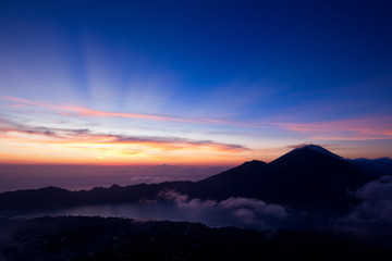 First rays of sunlight on top of Batur volcano in Bali