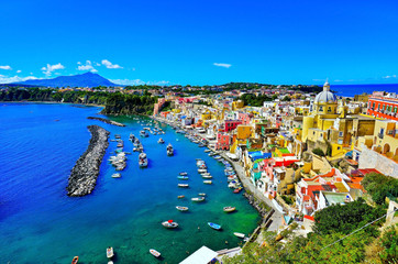 View of the Port of Corricella with lots of colorful houses on a sunny day in Procida Island, Italy.
