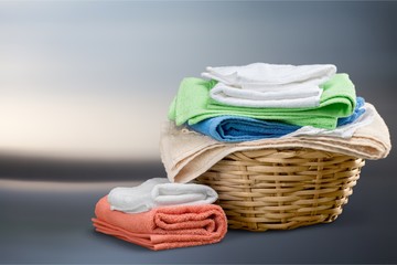 Laundry Basket with colorful towels on background