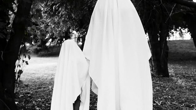 Father and son playing ghosts outdoor, halloween concept video