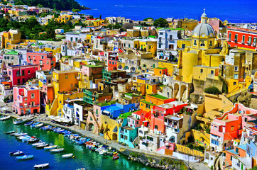 View of the Port of Corricella with lots of colorful houses on a sunny day in Procida Island, Italy.