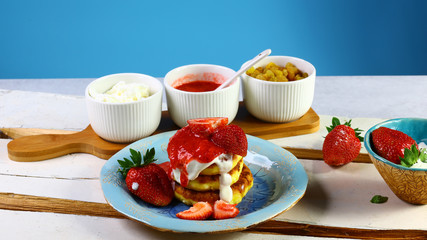 sweet breakfast Cheesecakes with sour cream, strawberry jam, and raisin. Authentic lifestyle image