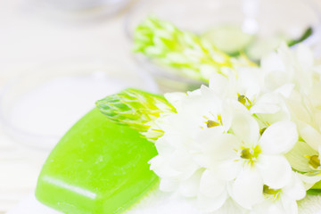 Cucumber home spa and hair care concept. Sliced cucumber, bottles of oil, grean soap, bathroom towel. Straw light background