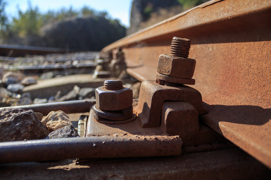 Rusty nuts on railway track close up, bokeh