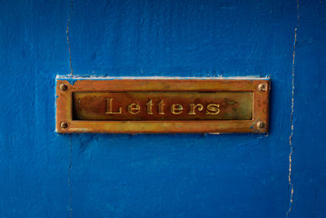 Retro golden mailbox in the door at blue background. Post