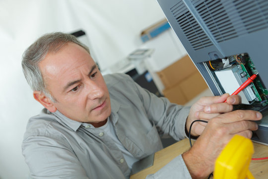 senior worker calibrating a machine