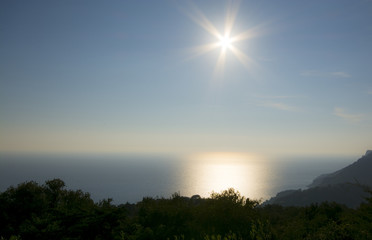 Sun whith rays at the sky above the light blue sea in Corfu Greece