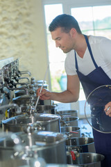 Man stirring contents of large saucepan