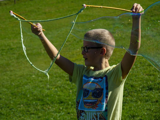 boy with huge soap bubble manufacturing