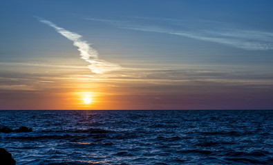bright pink-orange sunset and beautiful clouds on the background of the sea, Corfu, Greece