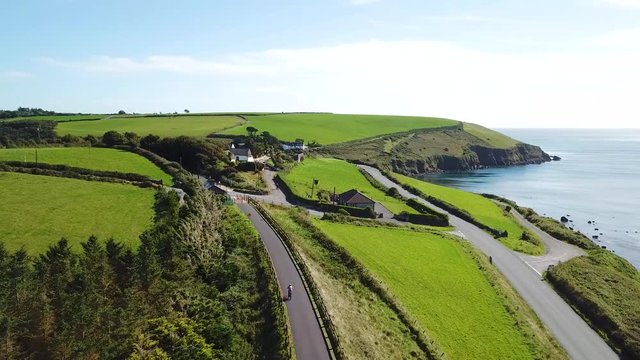 man cycling along the ocean coast. Waterford Greenway in Ireland 
