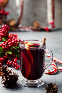 Mulled red wine with spices, orange slices on grey table. New year and Christmas background.