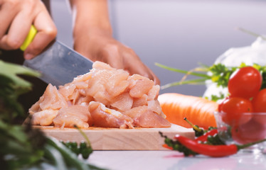 The chef is cutting the chicken meat for cooking