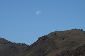 Fototapeta na wymiar Large Moon High over the Rocky Mountain Landscape