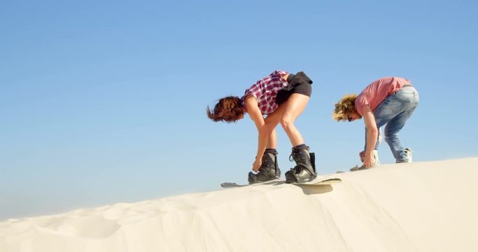 Couple attaching the sand boards to the boots 4k