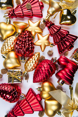 A top view of  mixed golden and red christmas ornaments on white background