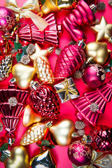 A top view of  mixed golden and red Christmas ornaments on red background