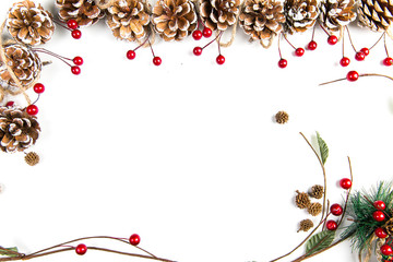 A top view of a christmas ornaments: pine cones awith red berries, curved twigs and pine needles on white background