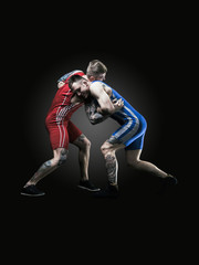 Fototapeta na wymiar two wrestlers figting isolated on black back