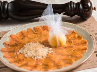 Sliced salted red fish with slices of lemon lies on a plate. Festive banquet.