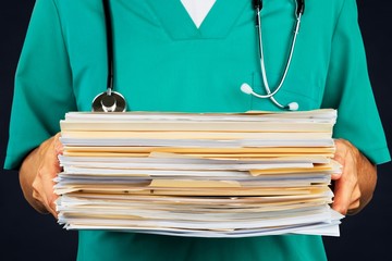 Doctor holding stack of papers on hospital