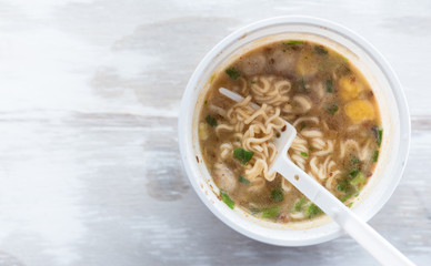 Instant noodle cup white on table wood,top view