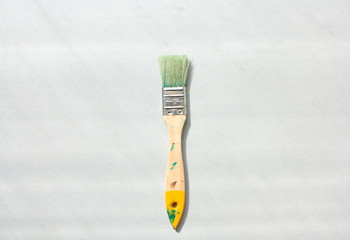 Wooden brush in paint on a gray background