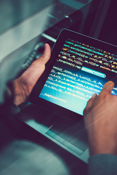 Hacker using computer, smartphone and coding to steal password and private data