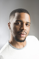 Obraz premium African peoples beauty concept. Macho with beard and smooth brown skin looks handsome. Man with beard and mustache in studio, grey background. Man on calm face with sensual big lips, close up