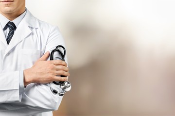 Male doctor with stethoscope on blurred hospital