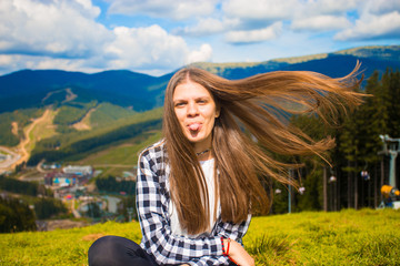 Happy tourist woman with fly hair on top of mountains, freedom and happiness concept