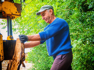 hydraulic log splitting machine attached to a tractor the machine is being used to split large...