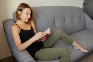 Fototapeta premium Beautiful girl reading a book at home