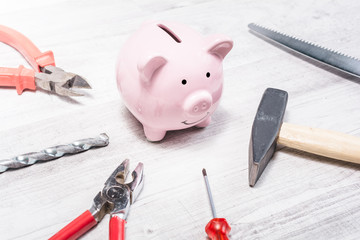 Pink Piggy Bank Surrounded By Tools Like Hammer, Pliers Or Saw - Open Piggybank Concept