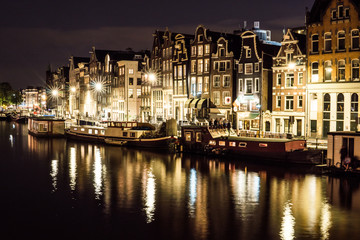 Night city view of Amsterdam channel and typical dutch houses, Holland, Netherlands.